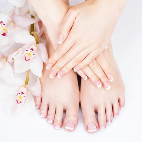 Closeup photo of a female feet at spa salon on pedicure and manicure procedure - Soft focus image